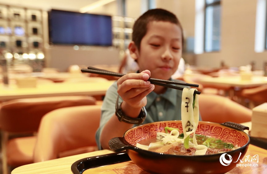 殷墟博物館推出的甲骨文面深受游客喜愛。人民網(wǎng)記者 慎志遠(yuǎn) 攝